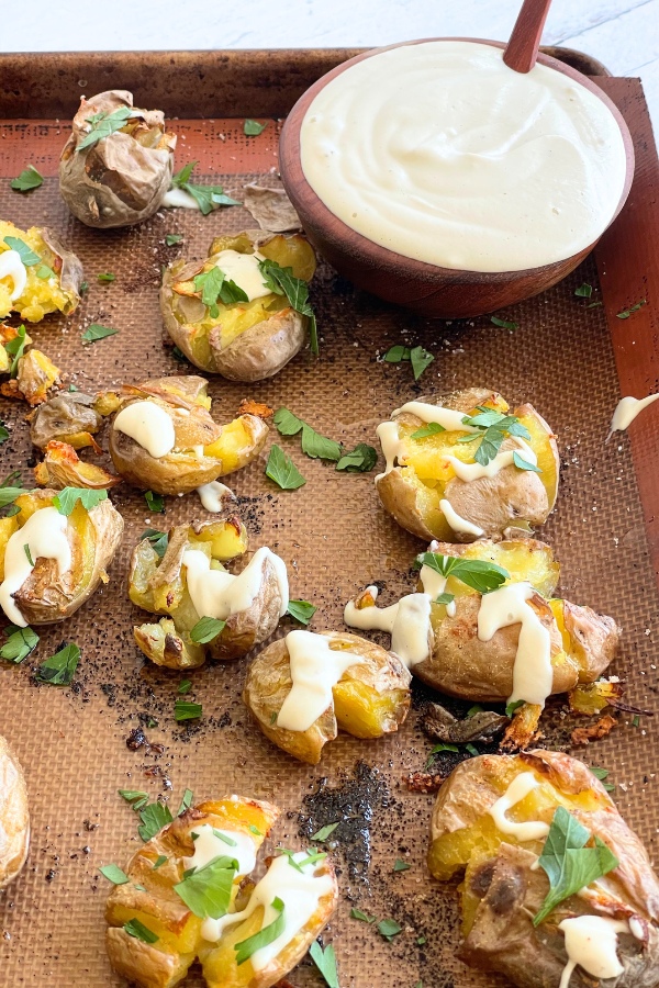 sheet pan with potatoes next to a bowl of truffle cream