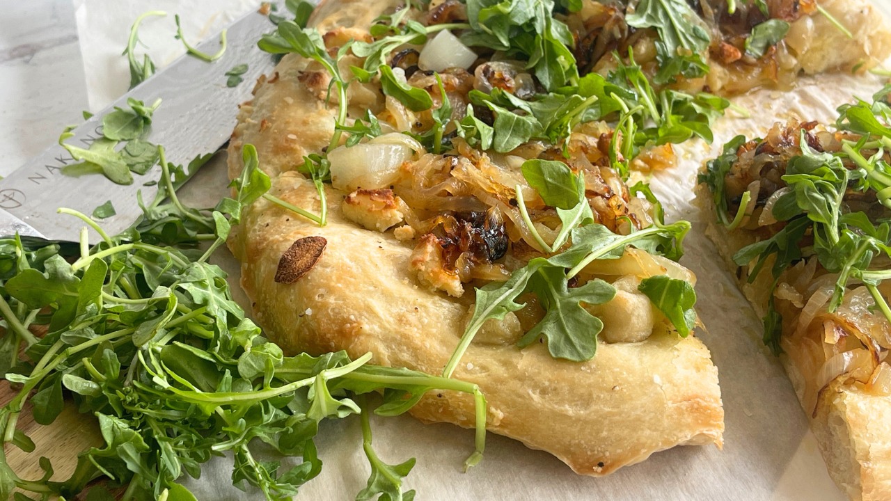 pizza with arugula on parchment paper