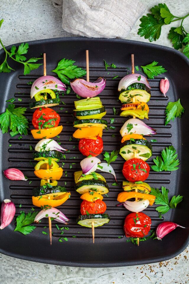 three vegetable kebabs on a grill pan