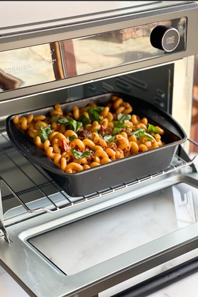 pan of mac and cheese on a rack inside a toaster oven