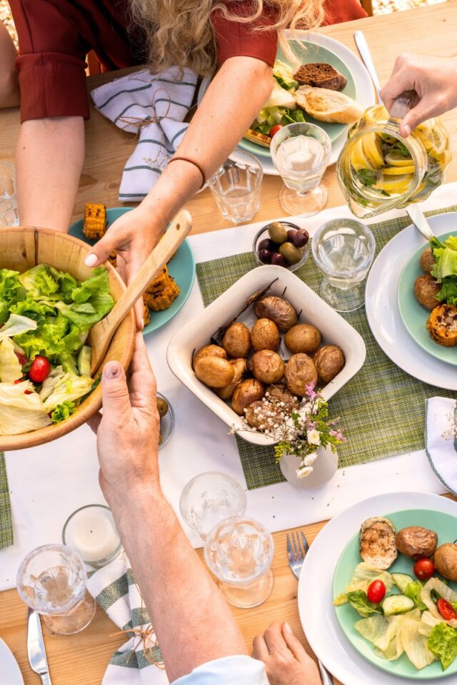 family sitting at a dinner table serving plates of food