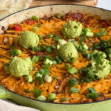 Casserole skillet filled with a Mexican rice dish topped with guacamole