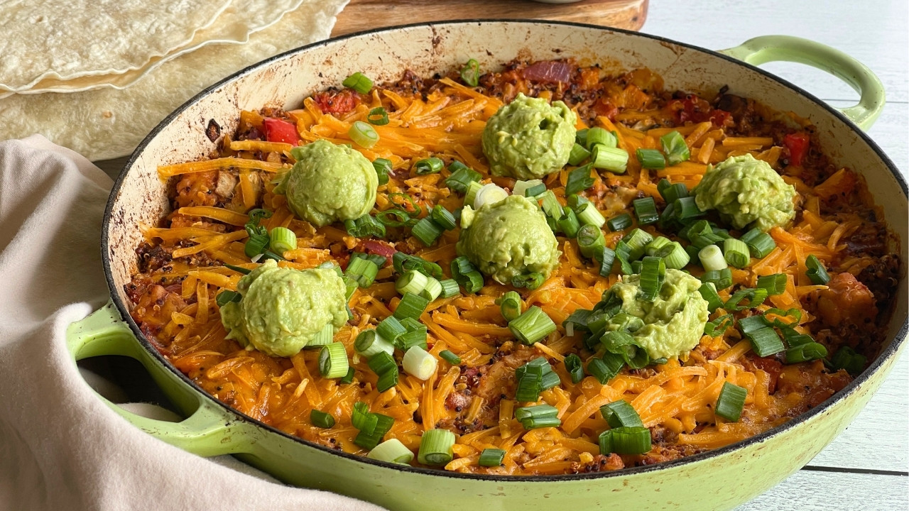 Casserole skillet filled with a Mexican rice dish topped with guacamole