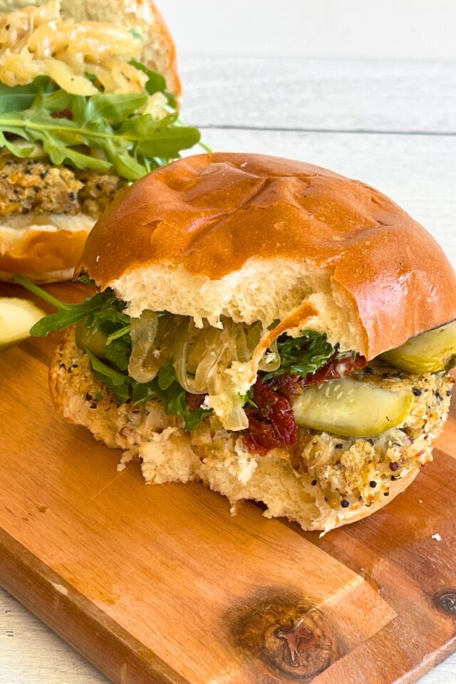 Half eaten burger on a wood cutting board