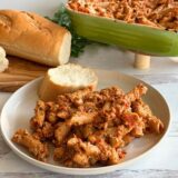 plate with penne pasta and marinara sauce on it and a slice of bread