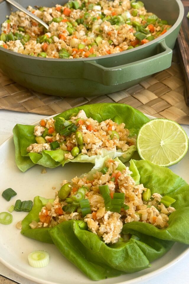 plate of lettuce wraps in front of a skillet of fried rice